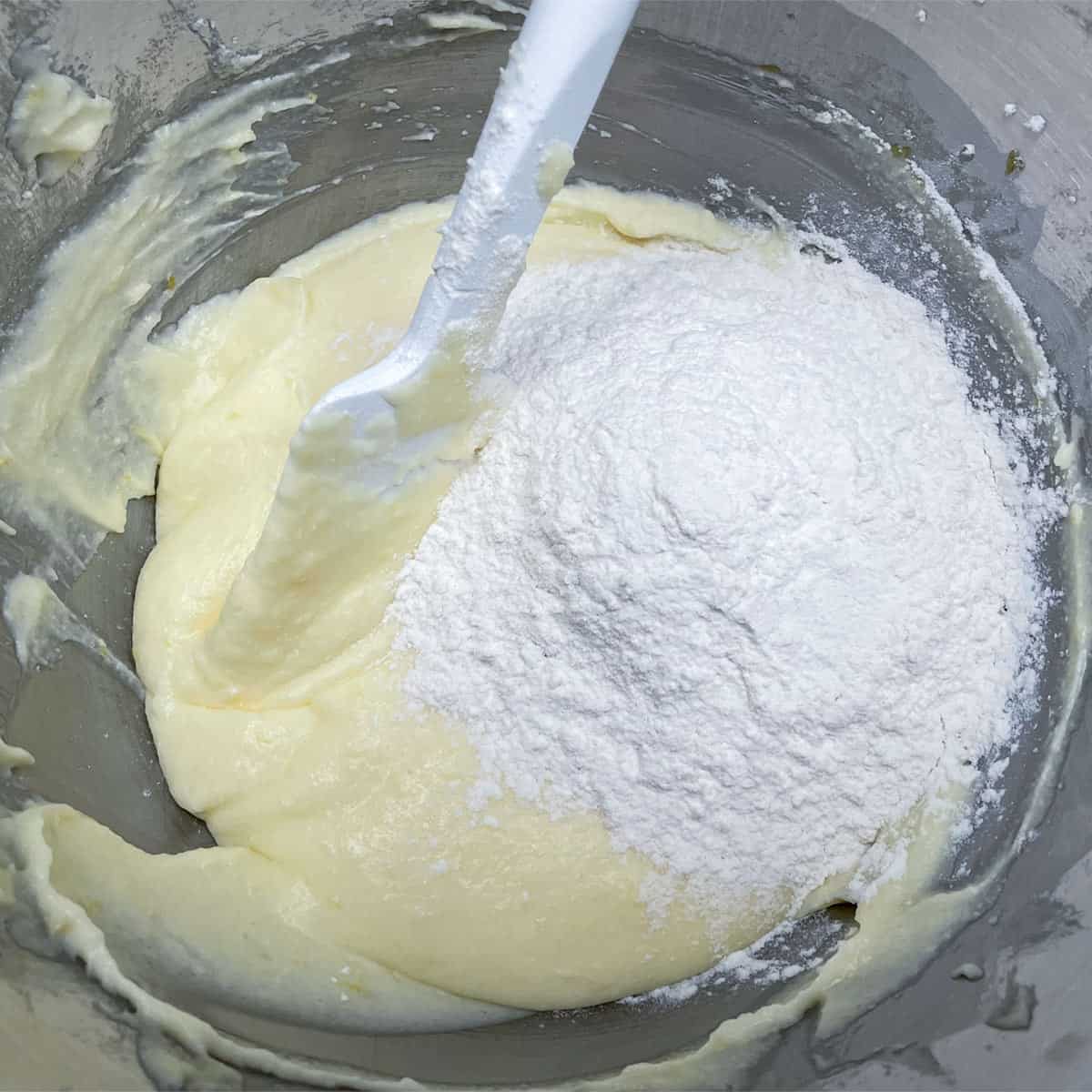Cookie dough in the bowl with a spatula folding in the flour mixture.