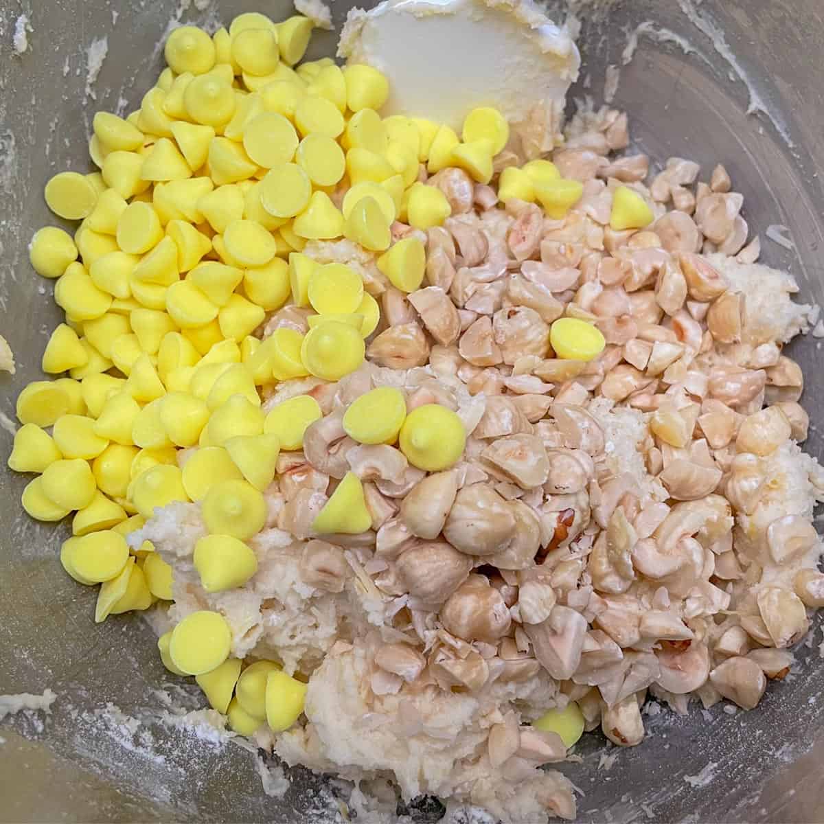 Adding the bright lemon chips and chopped hazelnuts at the end of mixing the cookie dough.