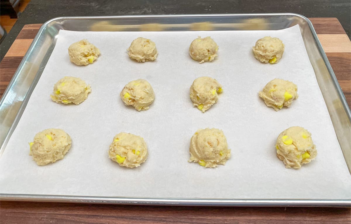 Cookie dough scooped onto a cookie sheet pan ready for the oven.