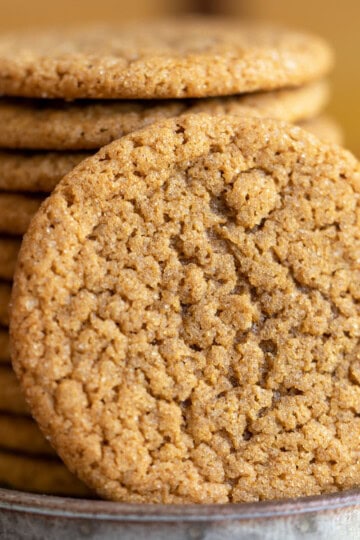 So good ginger cookies close up beside a stack of the cookies.