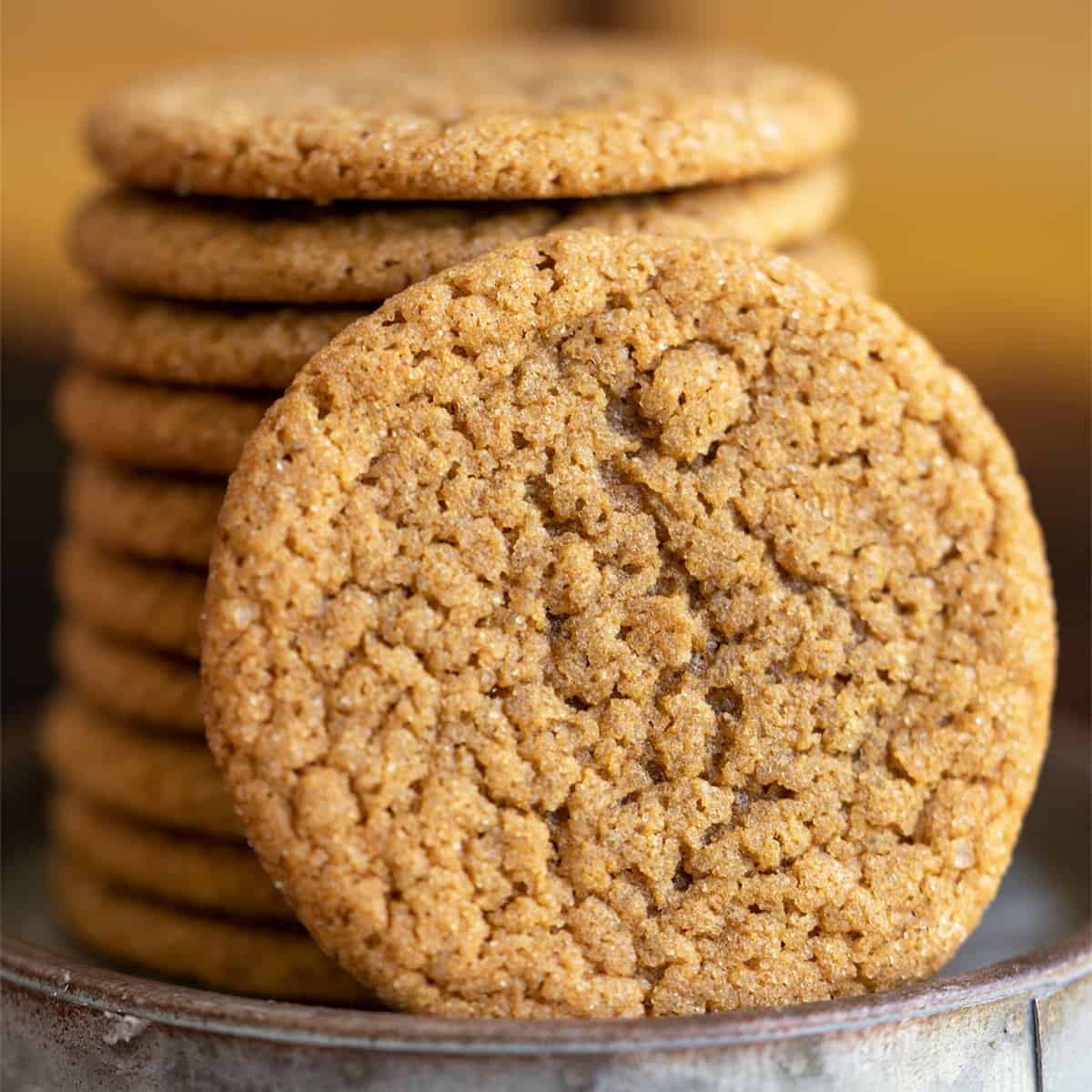 So good ginger cookies close up beside a stack of the cookies.