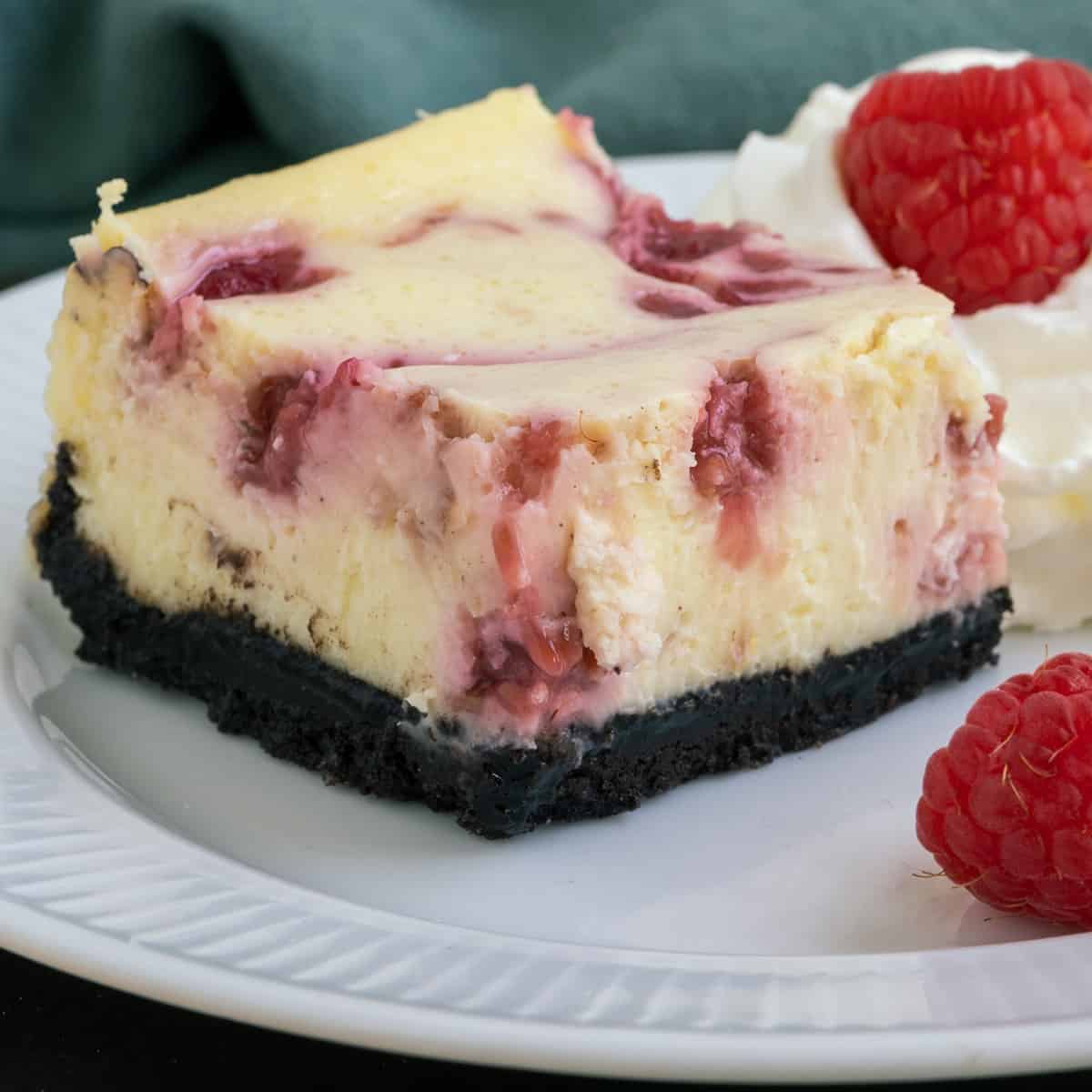 Raspberry Swirl Cheesecake Bite with darl chocolate Oreo crust closeup picture.