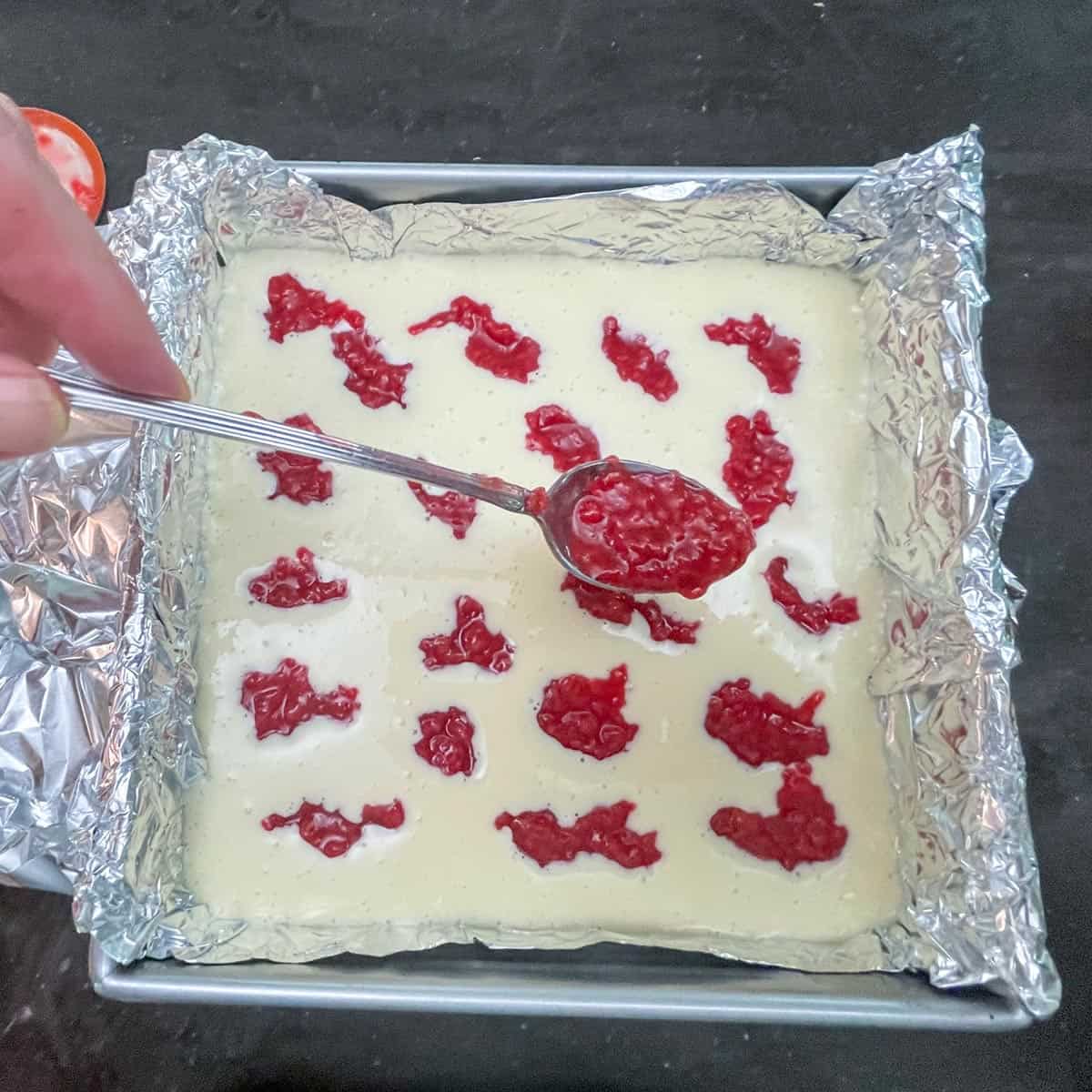 Spoonfuls of raspberry jam dropped onto the top of the unbaked cheesecake to make the swirls.