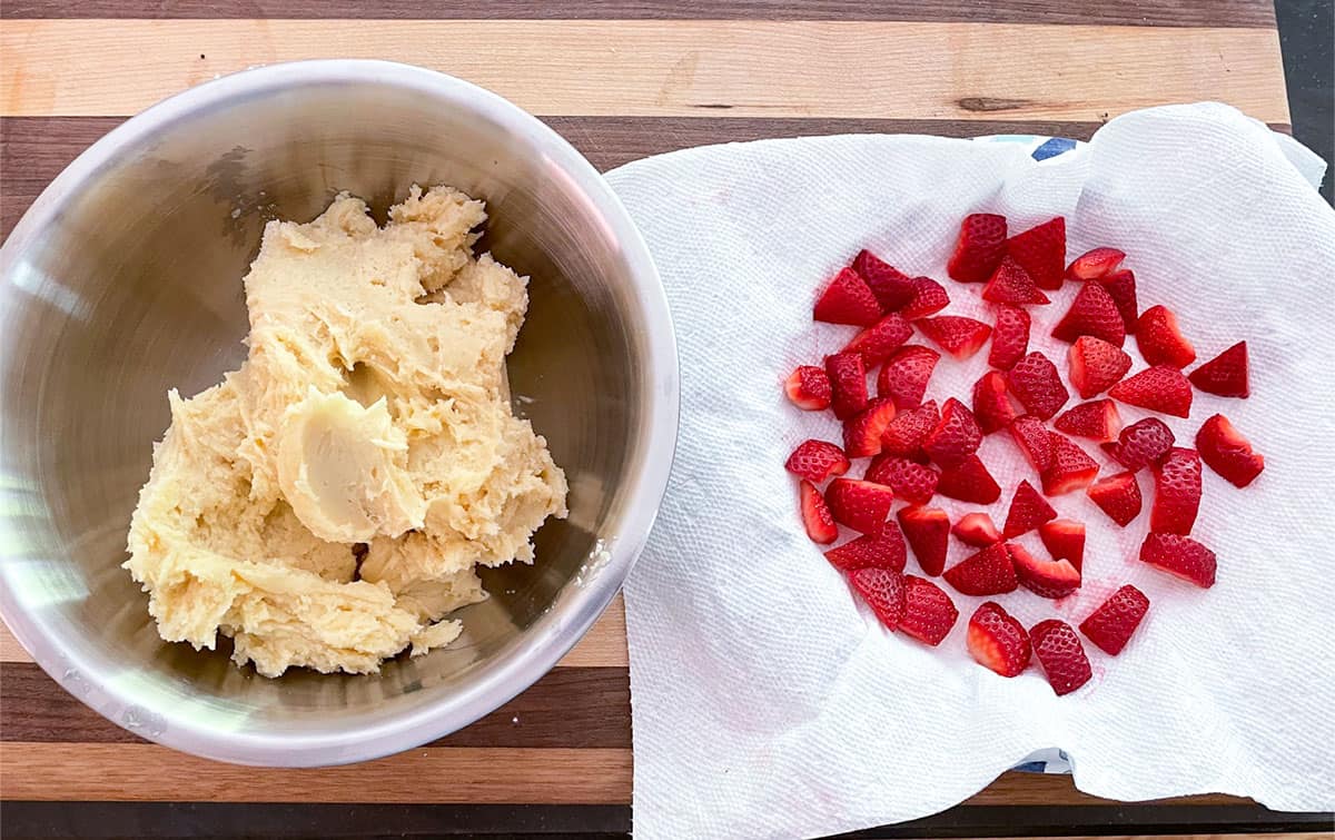 Cookie dough in a bowl and getting ready to fold in cut up fresh strawberries.