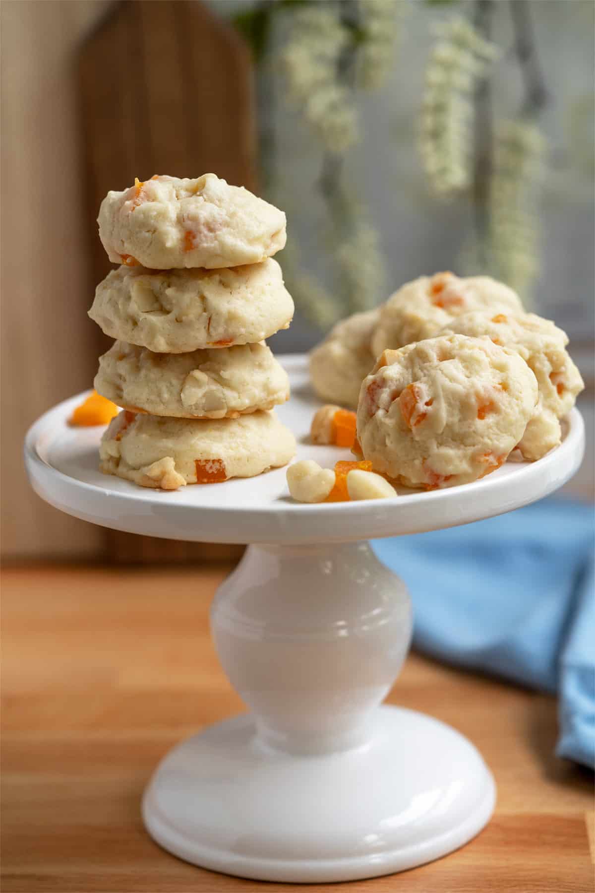 Display of eight mango lime with macadamia nut cookies on a white pedestal.