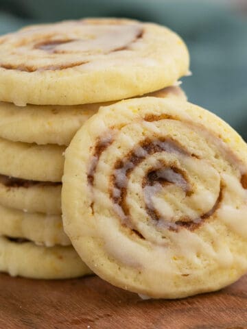 Close-up of a cinnamon orange pinwheel cookie with drizzles of icing zigged zagged across the top of the cookie.