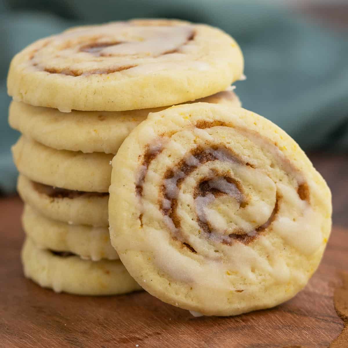 Close-up of a cinnamon orange pinwheel cookie with drizzles of icing zigged zagged across the top of the cookie.