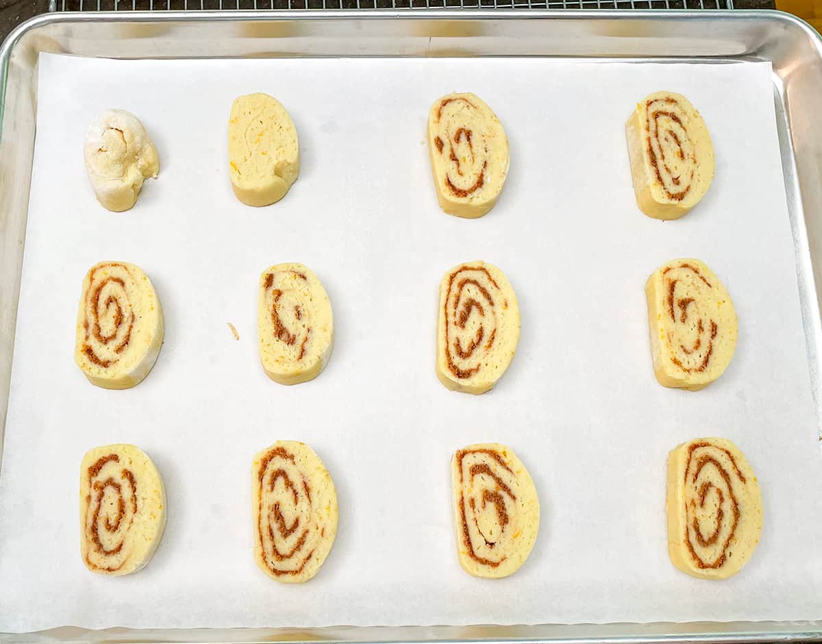 Sliced cookies on a parchment-lined sheet pan.