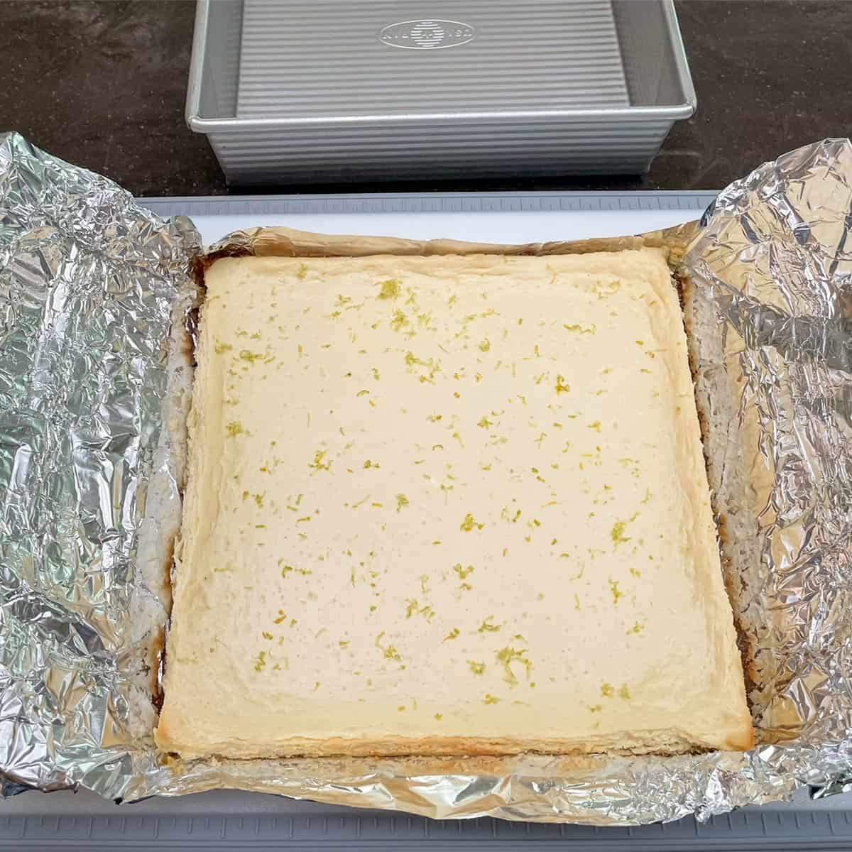After pulling the whole cheesecake out of the pan by the tinfoil handles and setting it on a cutting board.
