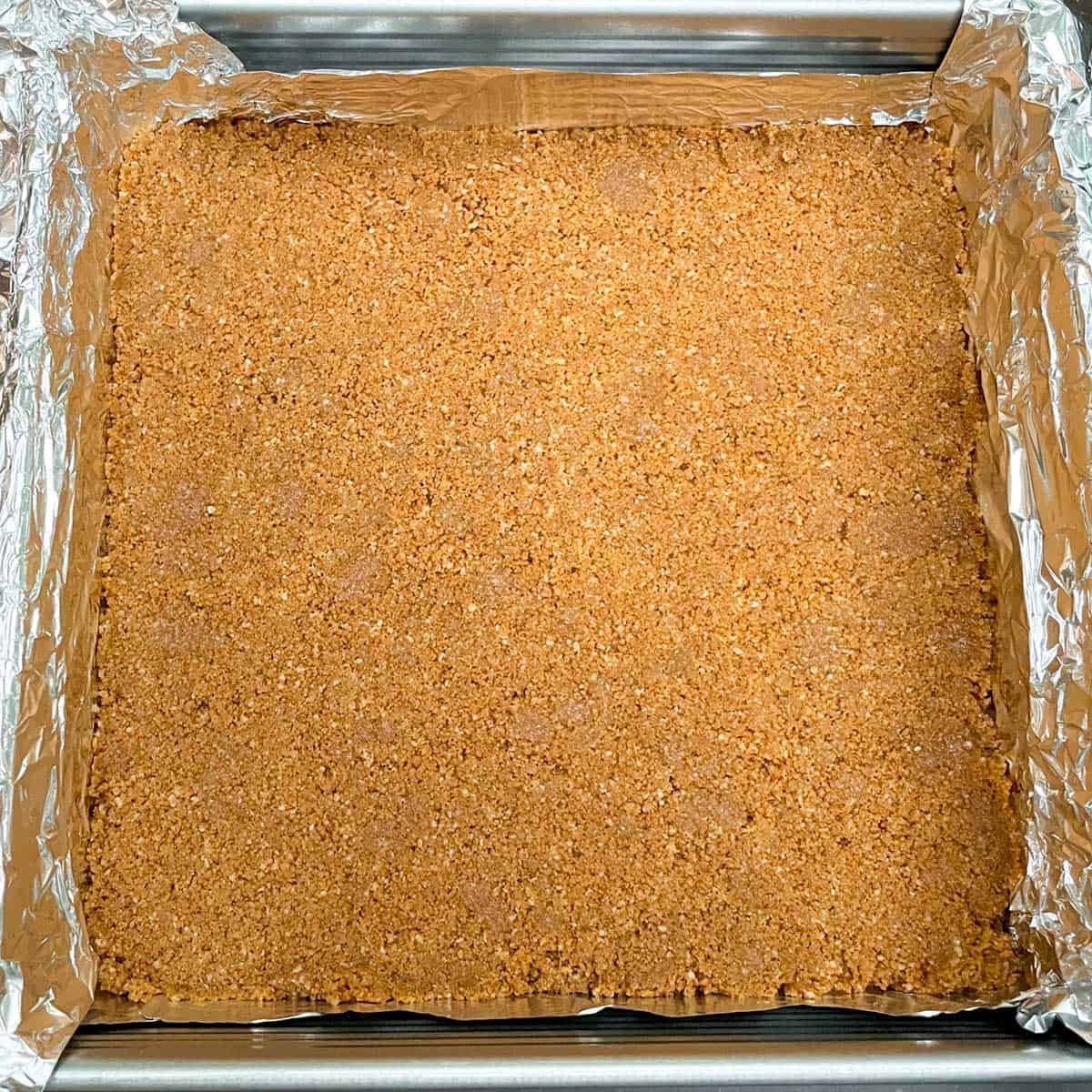 Pressed graham cracker crust ready for the cream cheesecake filling.