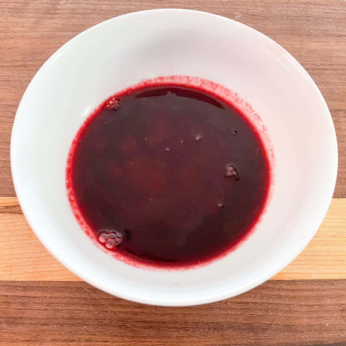 Strained cooked blackberry juice in a small bowl.
