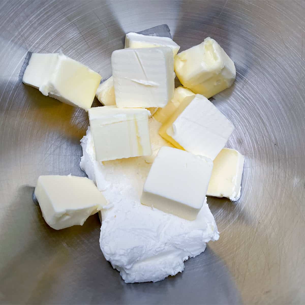 Cream cheese and butter cubes in the mixer bowl.