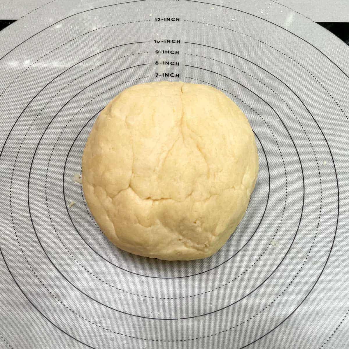 Kneading the cookie cup dough into a ball on a pastry mat.