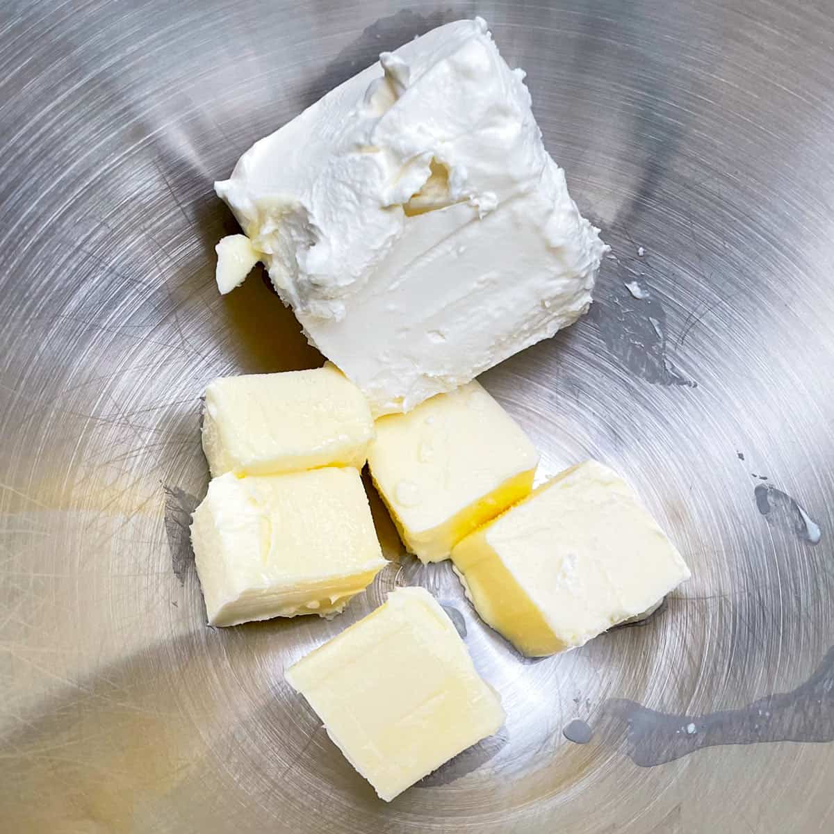 Cubed butter and block of cream cheese ready to be creamed with a mixer.