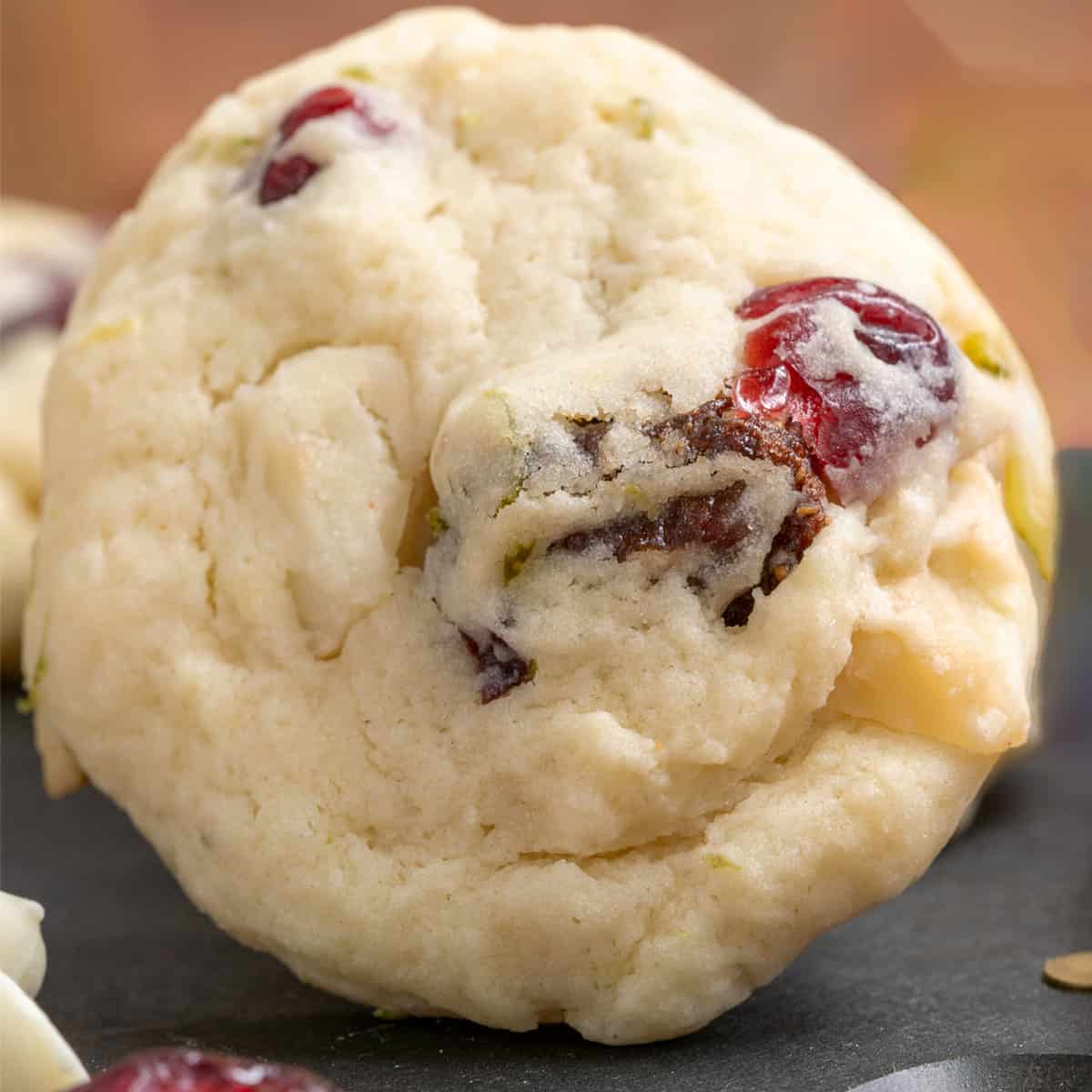 Close up picture of a lime with dried fruit and macadamia nut cookie.