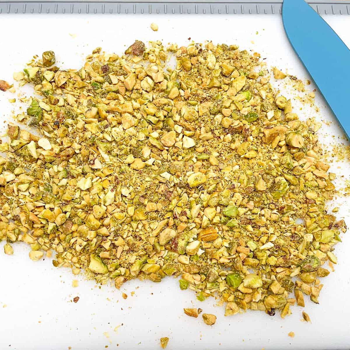 Chopping pistachios into very small pieces for topping.