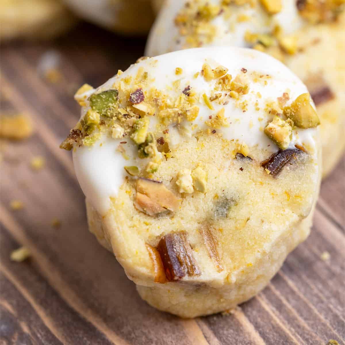 Pistachio date and orange cookies on a wooden plank close-up.