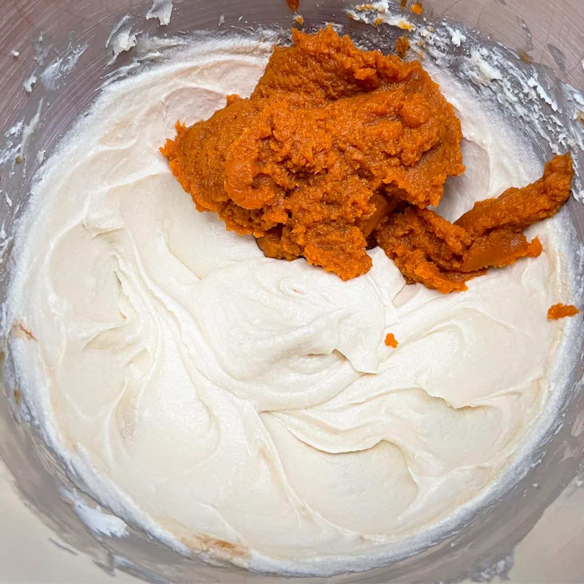 Add pumpkin puree to creamy-looking butter and cream cheese to be mixed.