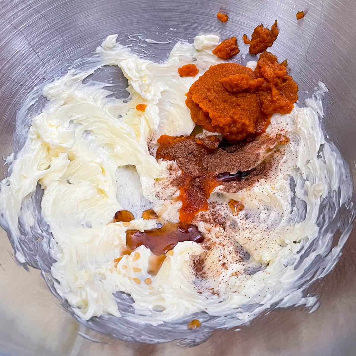 All the ingredients put into the mixer bowl for the pumpkin frosting.
