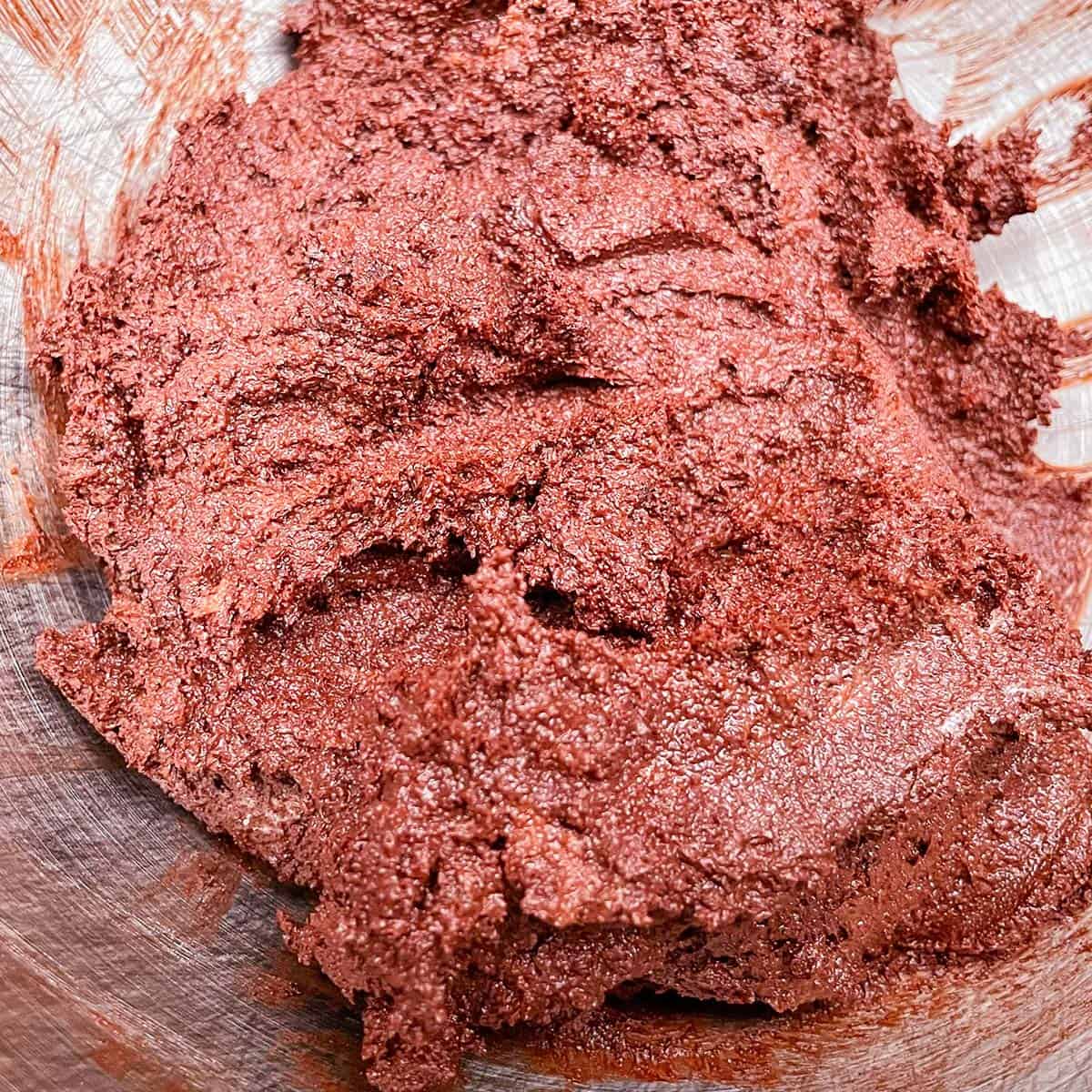 All the ingredients for Mexican Chocolate Crinkle Cookies have been mixed and in the mixer bowl.