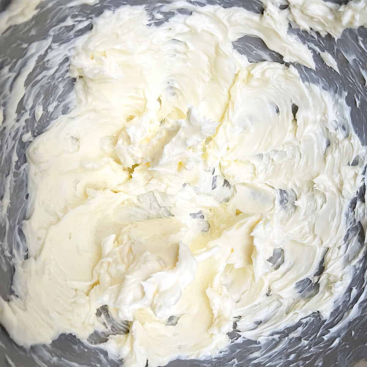 Creamed butter in a mixer bowl. It has soft peaks after mixing for 3 minutes.