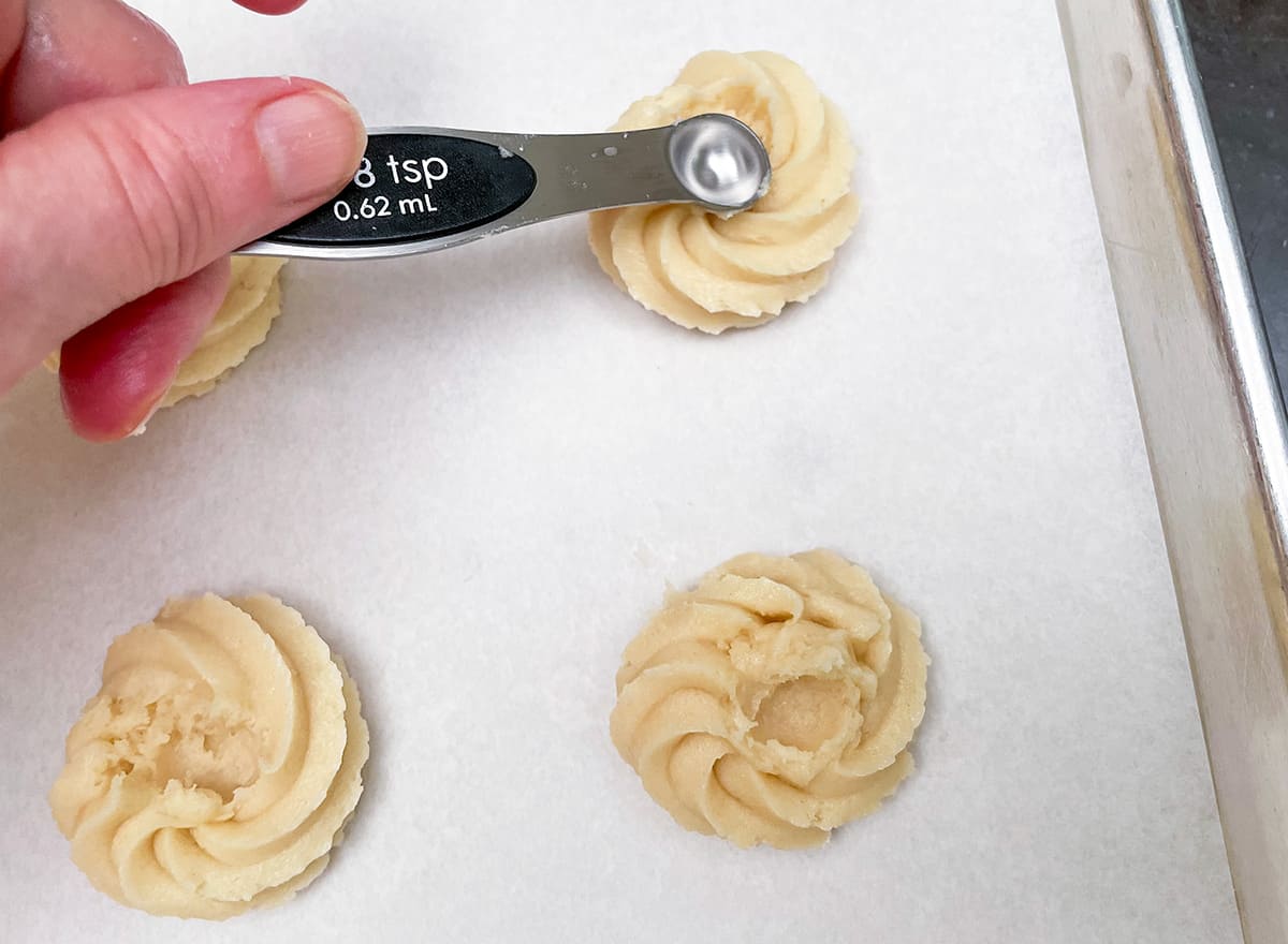 Using a ⅛" measuring teaspoon to make an indent in the middle of the rosette for the jam.