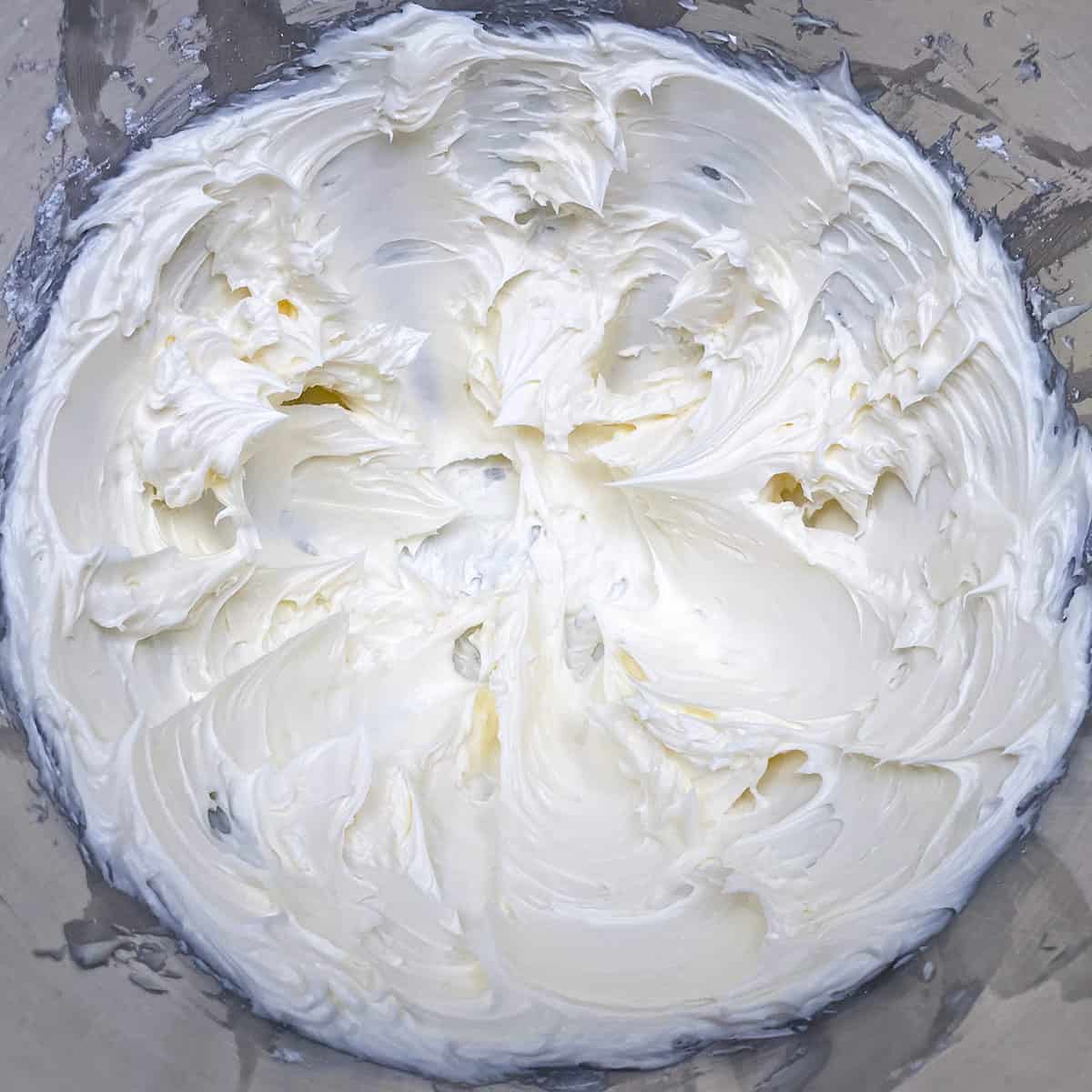 Soft peaks of creamed butter and powdered sugar after 3 minutes being mixed.