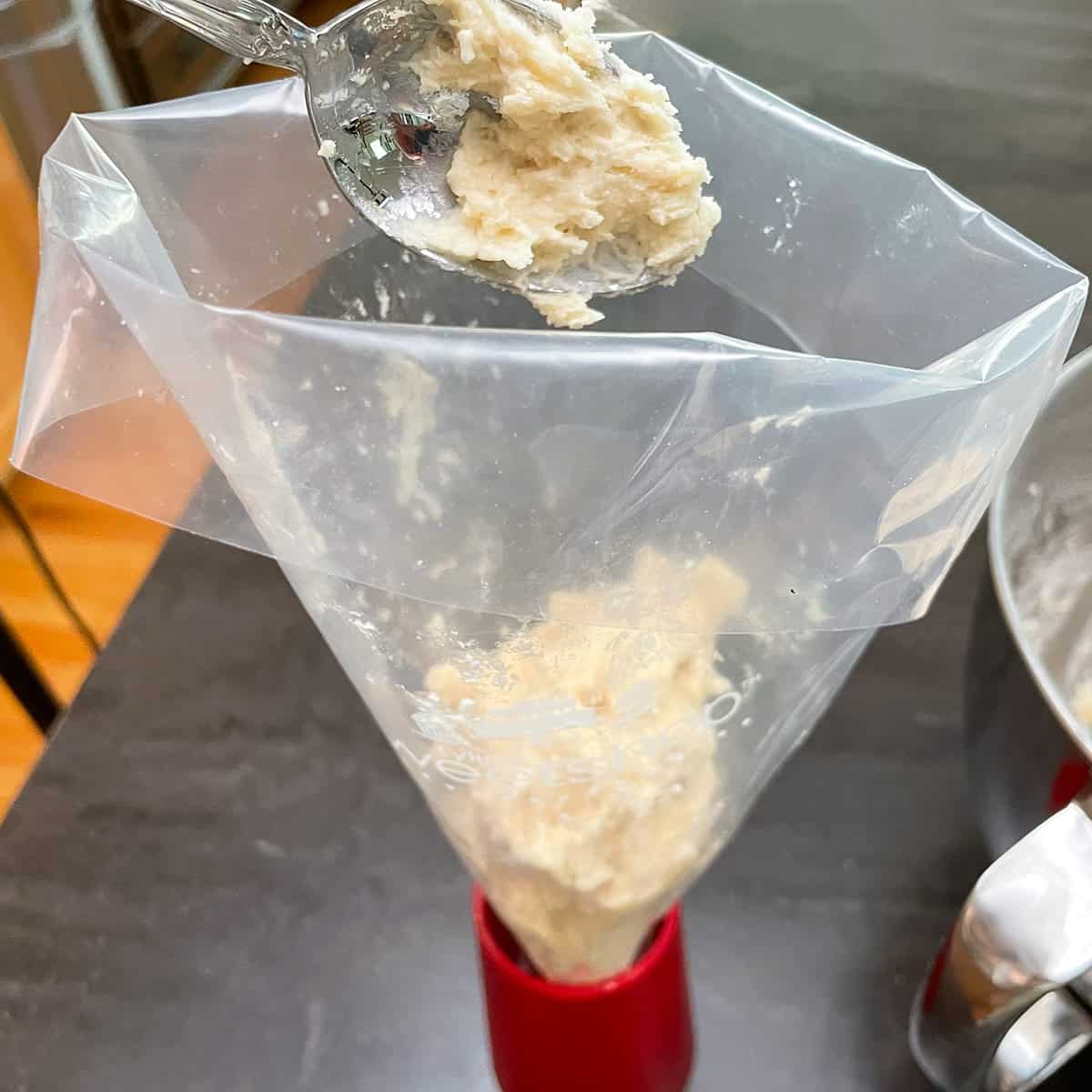 Adding cookie dough to a piping bag.