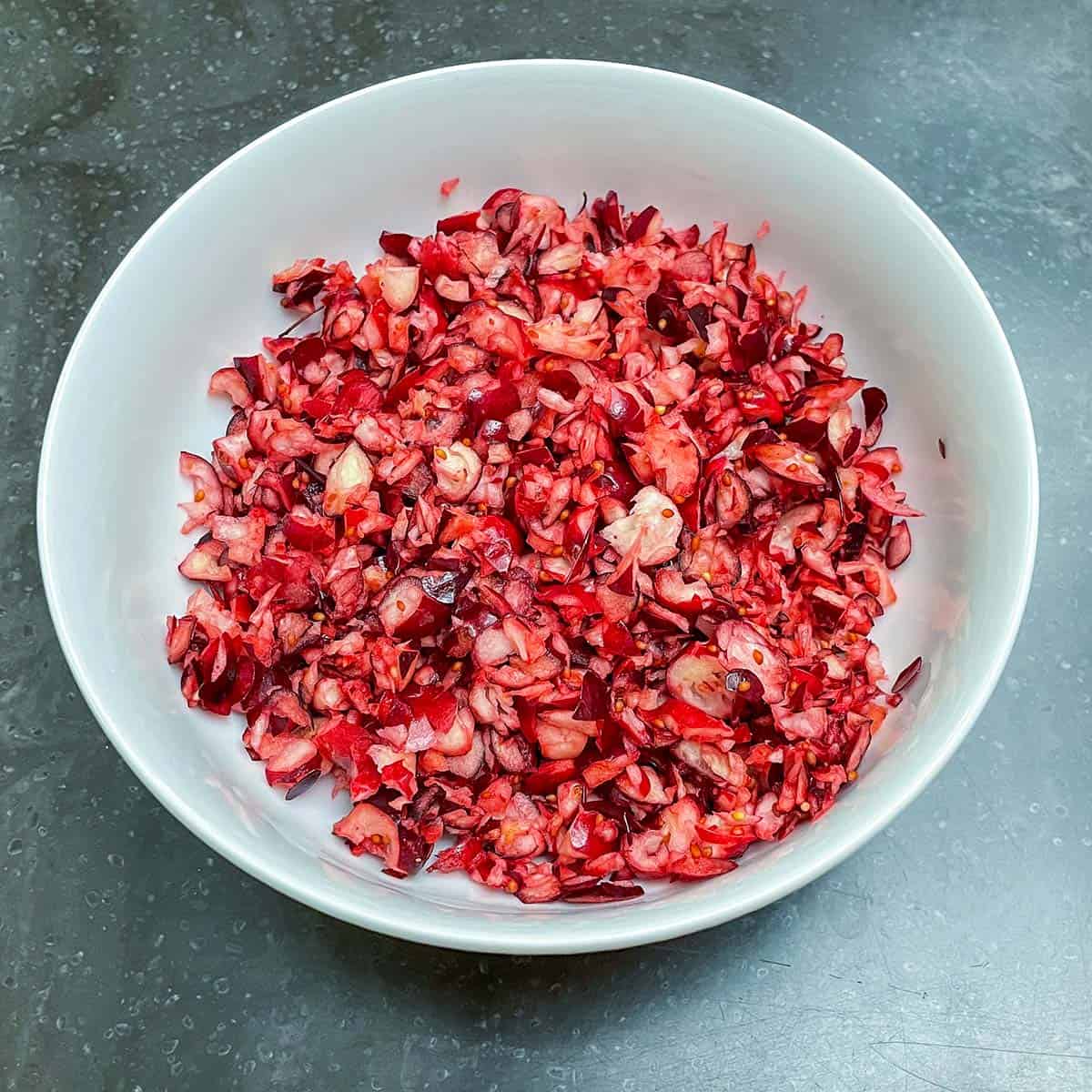 Chopped fresh cranberries in a bowl.