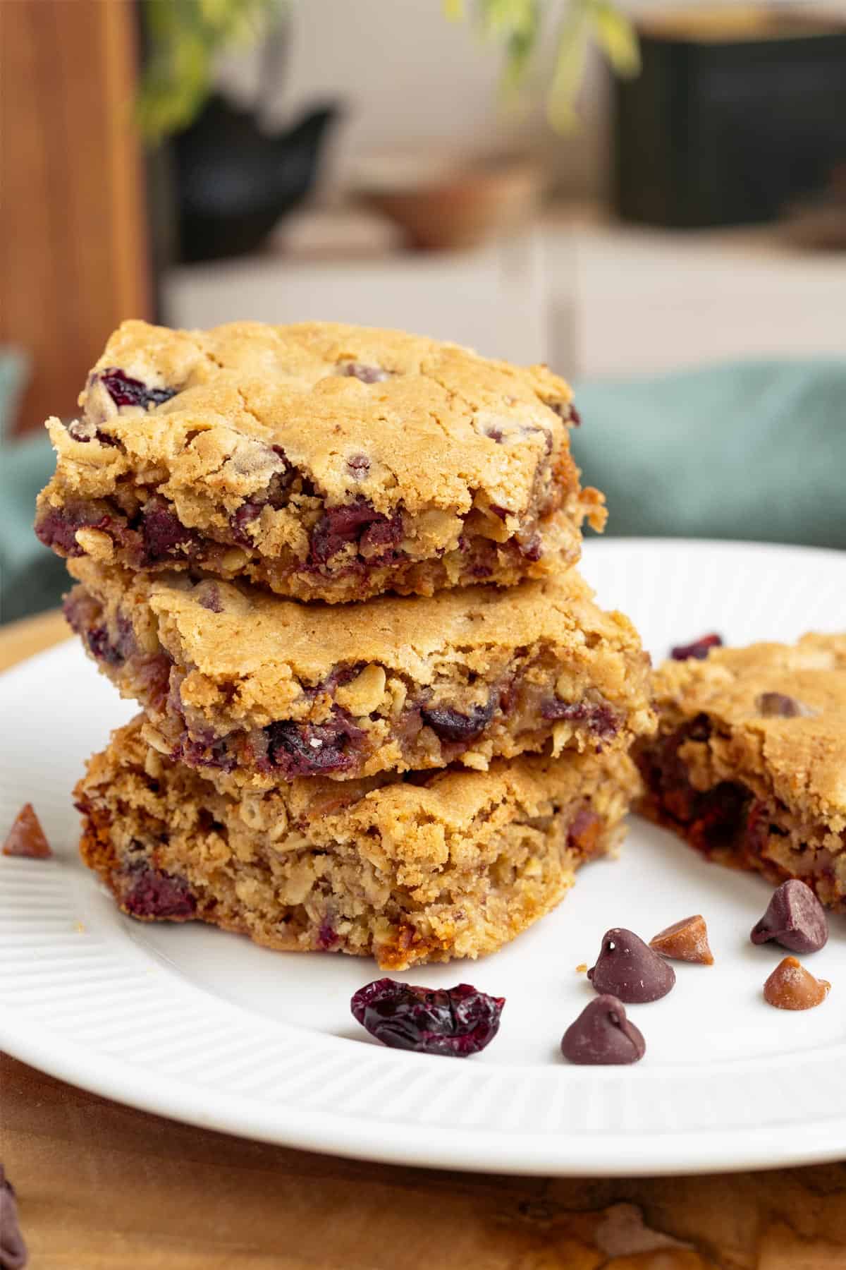 Cut cranberry cinnamon chocolate chip bars sitting stacked on a plate.