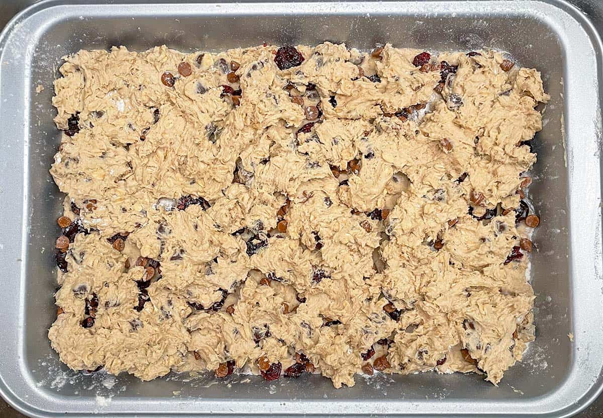Smoothed out spoonful's of cookie dough dropped on top of the cranberry and cinnamon chips and ready for baking.