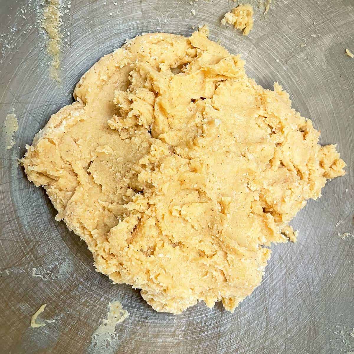 All the pumpkin spritz cookie dough mixed together in a mixer bowl.