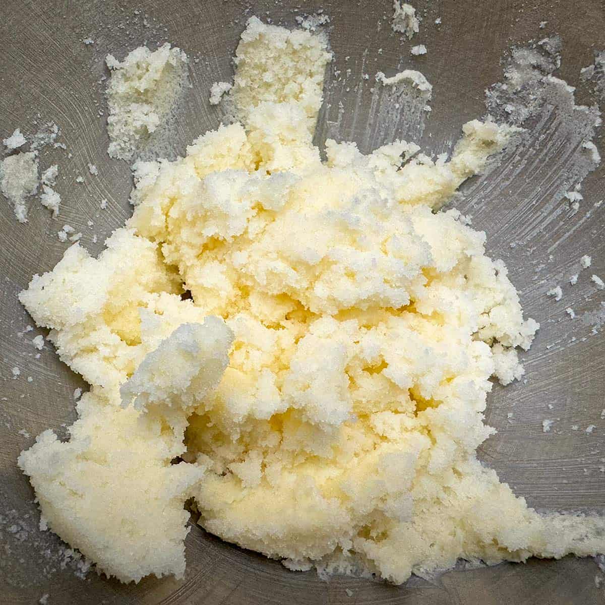Butter and sugar are mixed in a mixing bowl.