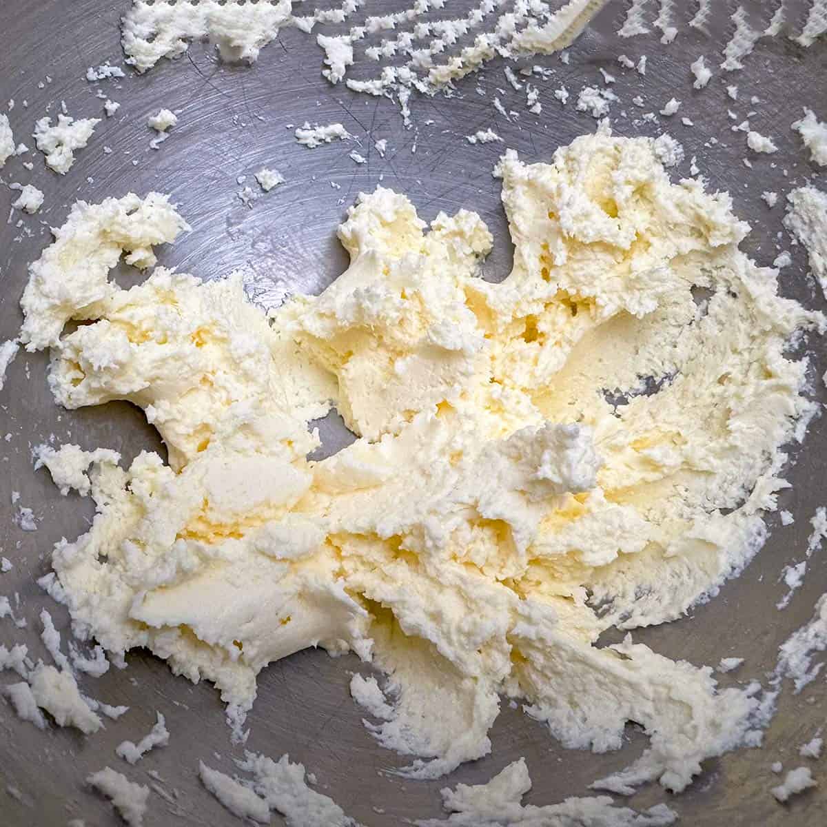 Butter and cream cheese mixed in a mixer bowl.