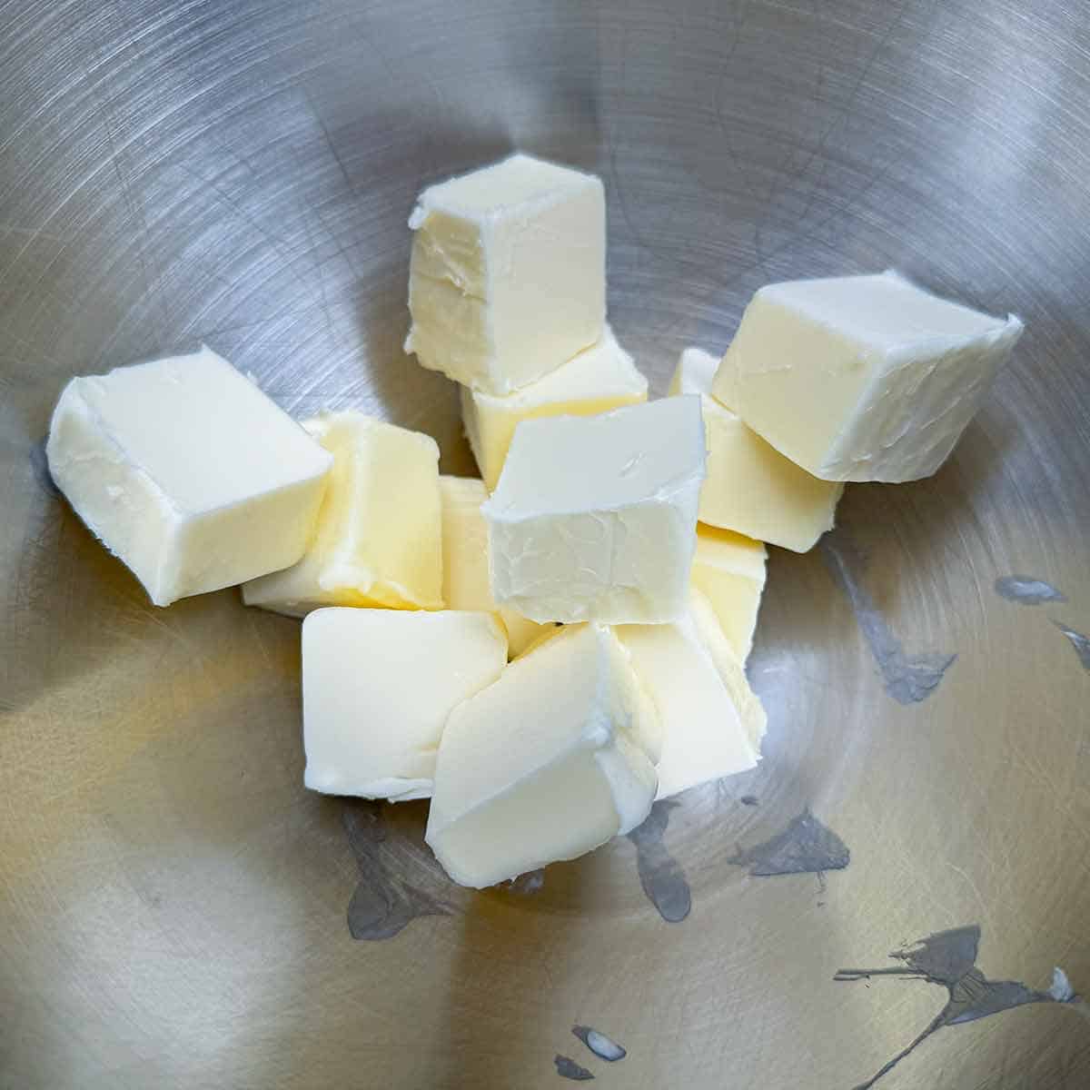 Butter cut up in a mixer bowl.