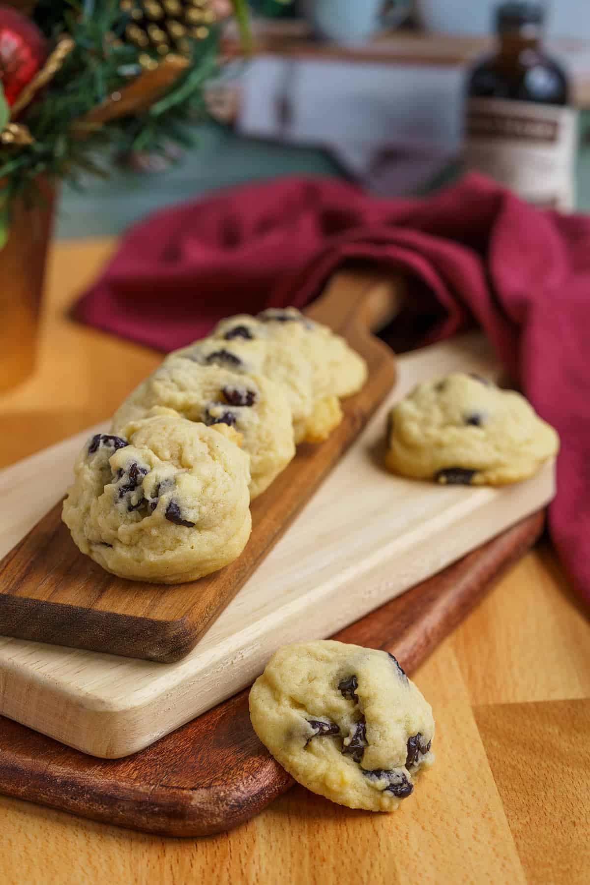 Six cookies on a stack of cutting boards with so many dried cherries in each cookie.