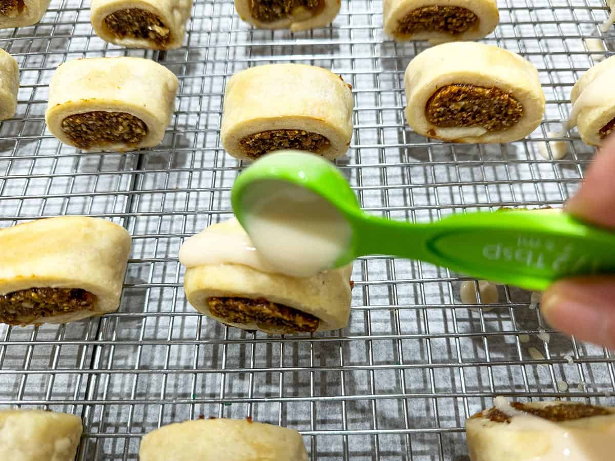 Adding the vanilla glaze to the tops of the fig cookies.