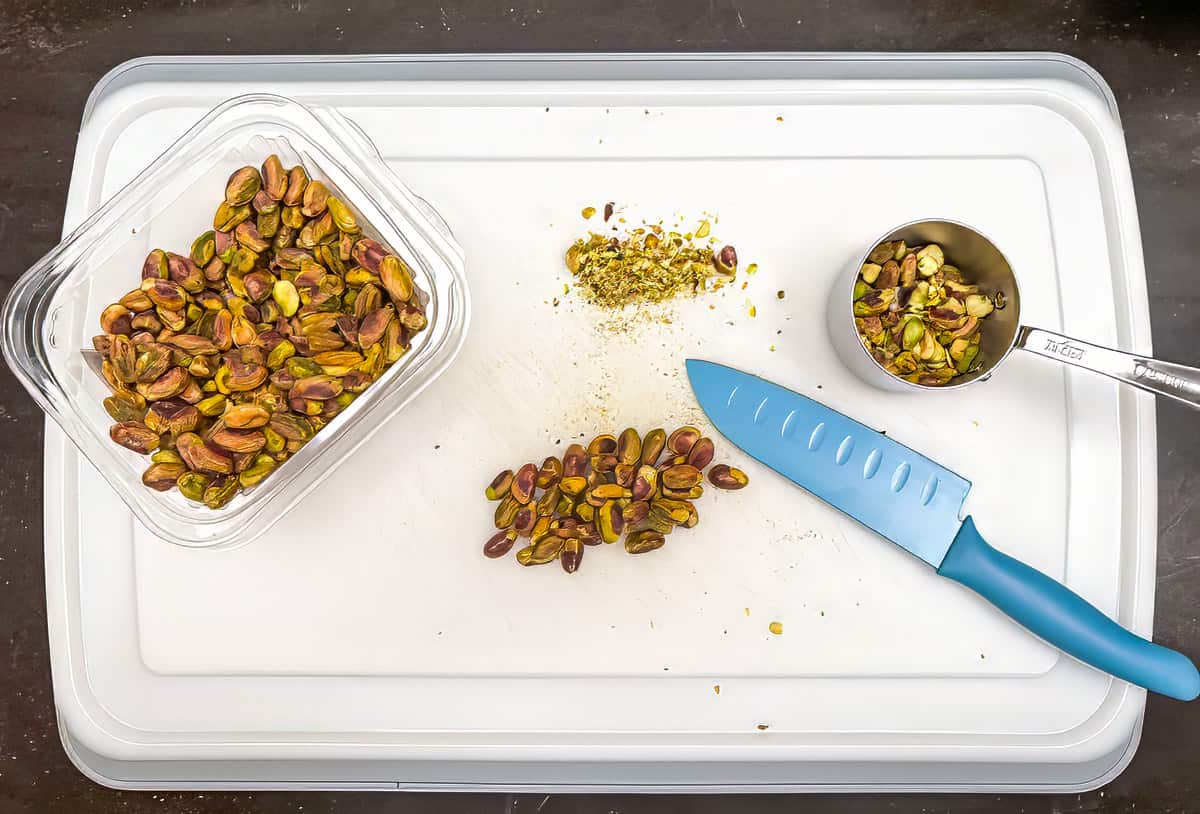 Chopping pistachios on a cutting board.