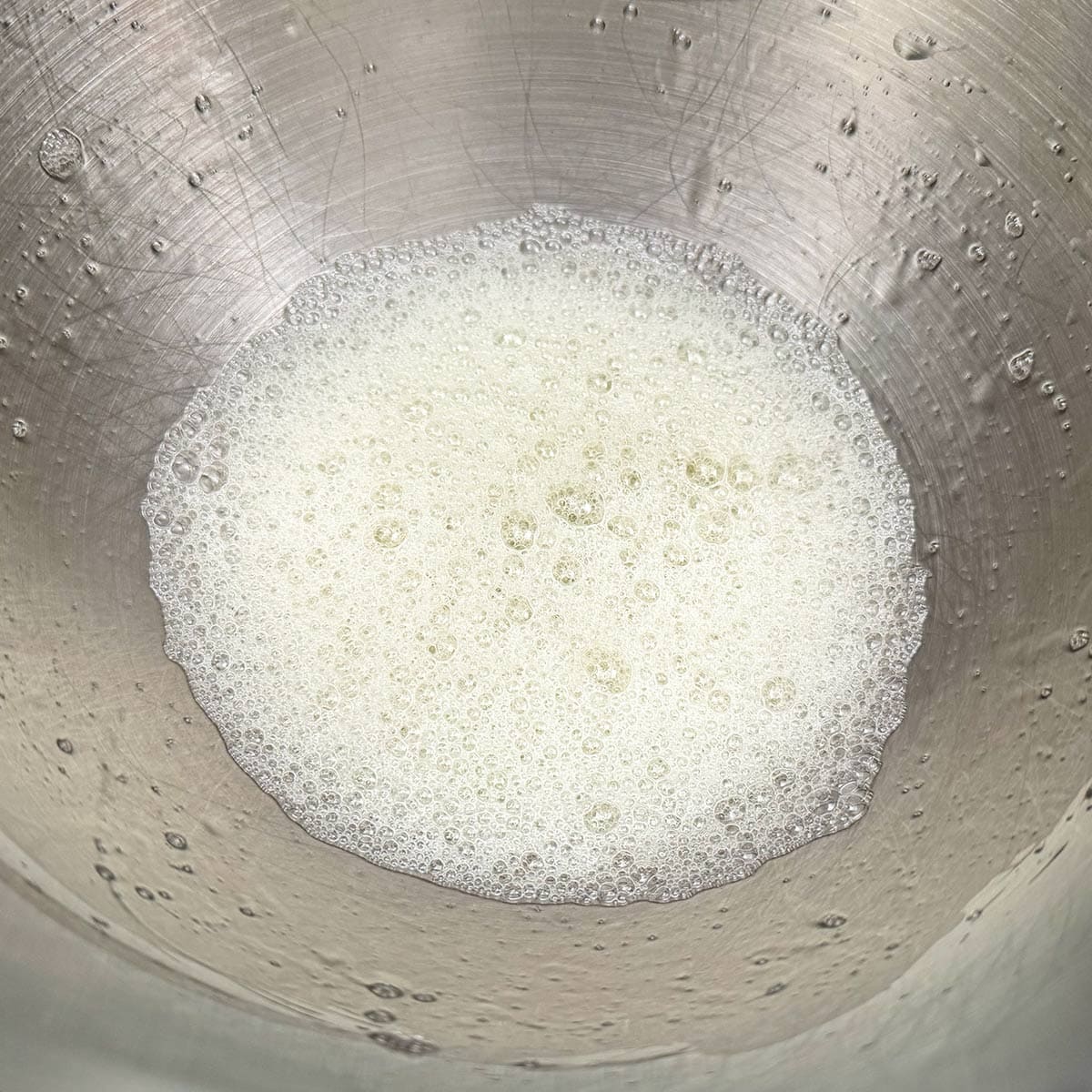 Frothy egg whites in a mixer bowl.