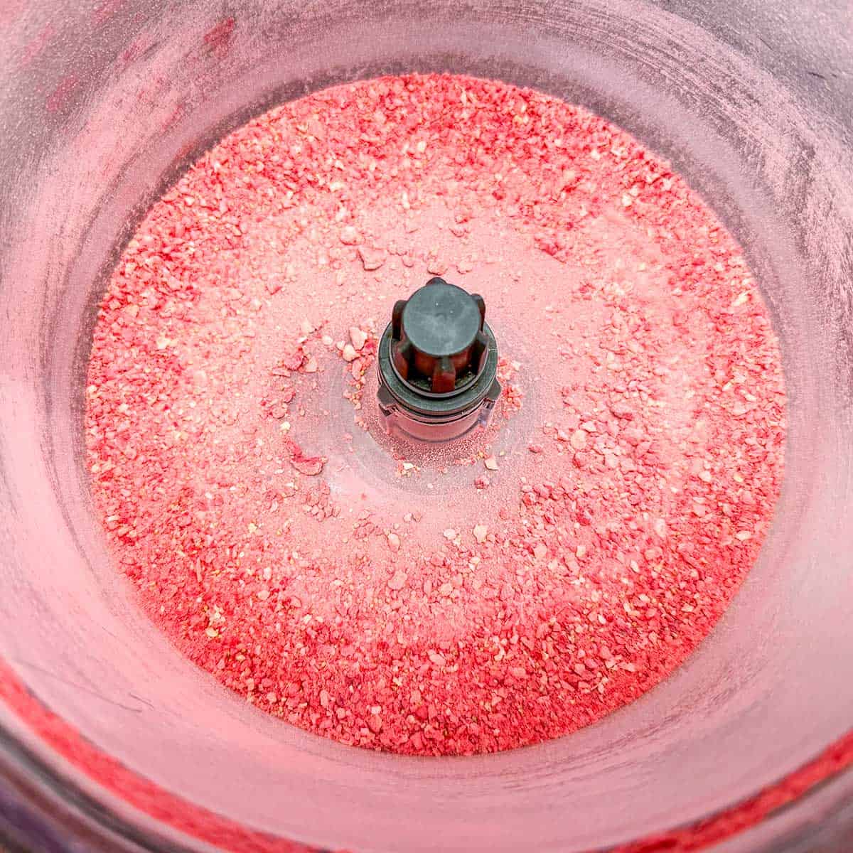 Using a food processor to crush freeze-dried strawberries to dust.