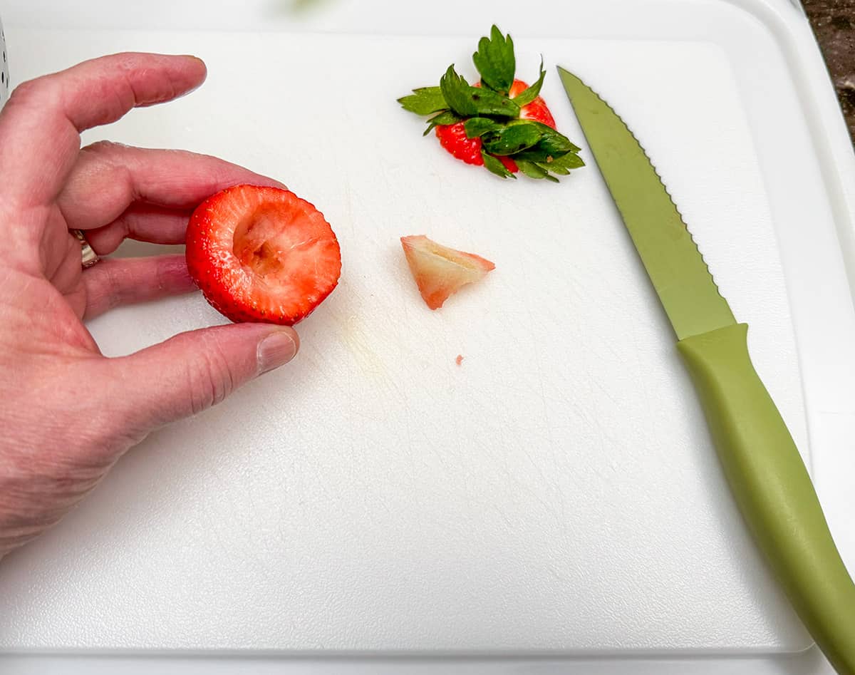 How to haul a strawberry using a knife to cut the middle out.