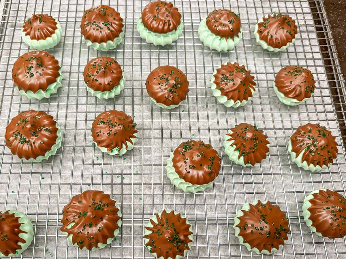 Irish Mint Chocolate Meringue cookies dipped into chocolate and sprinkled with green sparkles.