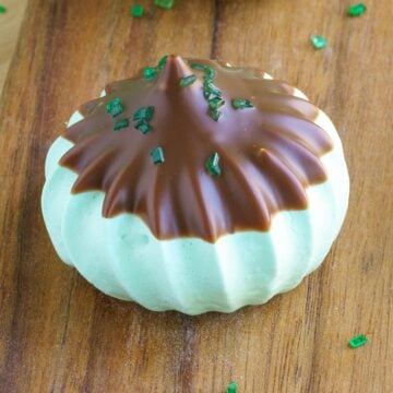 Single Irish mint chocolate meringue cookie on a wooden board.