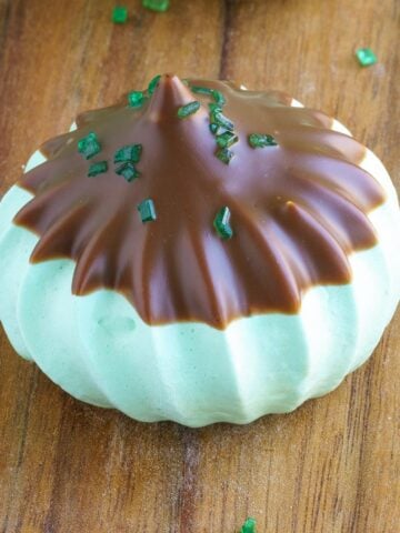 Single Irish mint chocolate meringue cookie on a wooden board.
