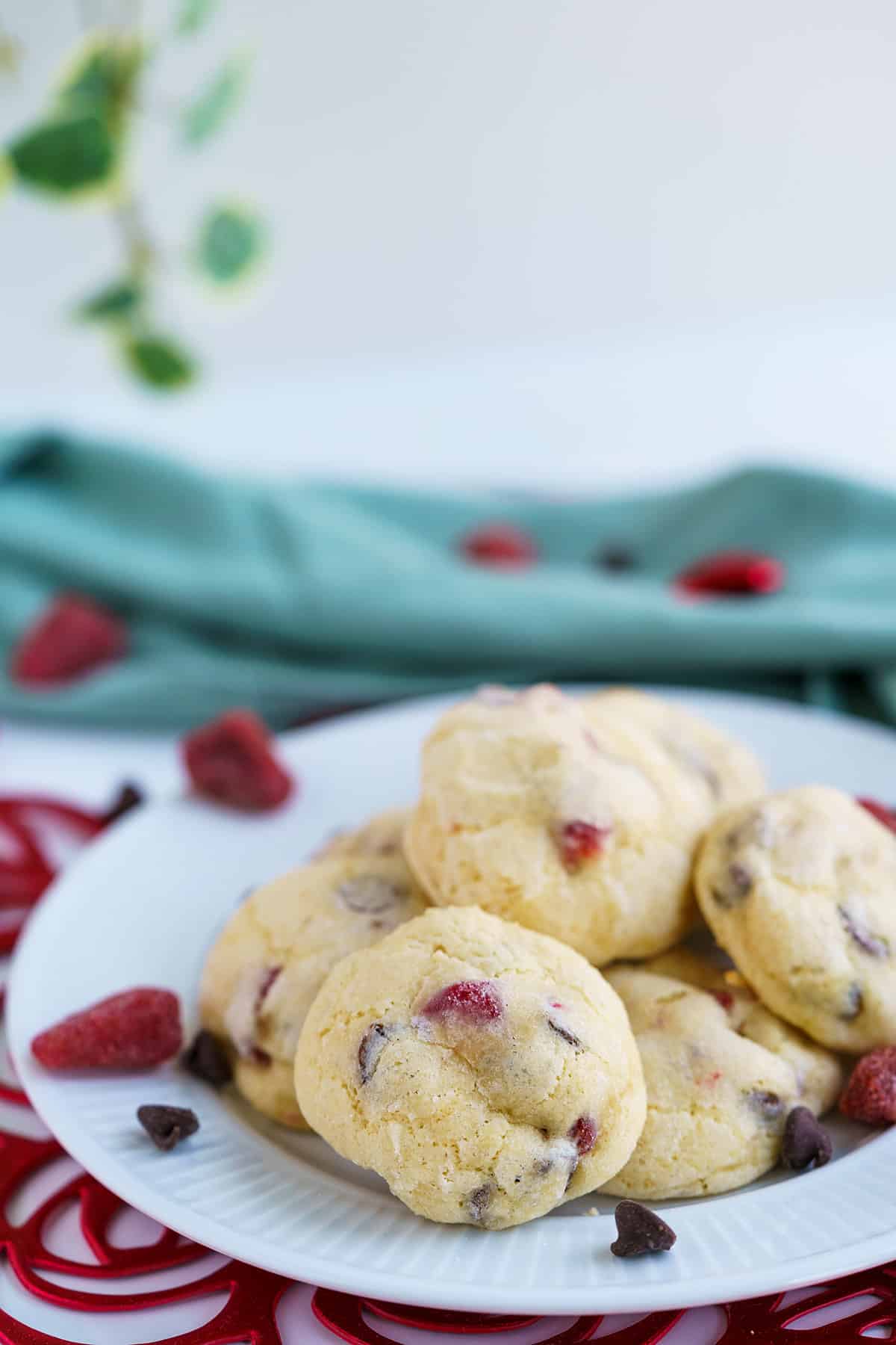 Chocolate chips and strawberry cookies on a plate with leaves in the background.
