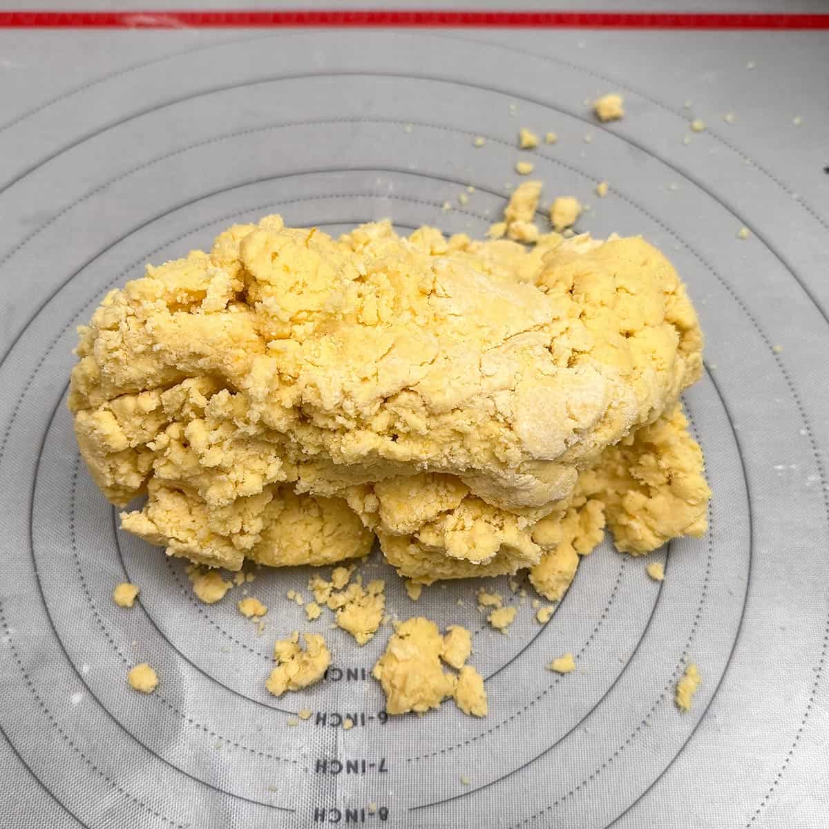 Cookie dough dumped onto a pastry mat. Looks dry and crumbly like playdough.