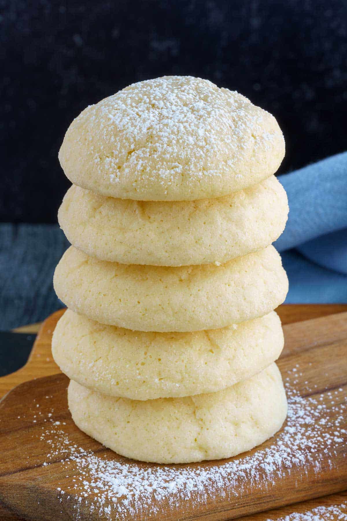 A stack of cream cheese cookies with powdered sugar sprinkled on top.