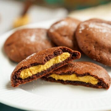 Peanut butter stuffed chocolate cookies split in half to show the peanut butter inside.