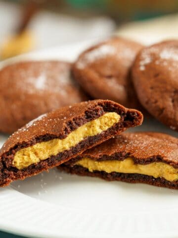 Peanut butter stuffed chocolate cookies split in half to show the peanut butter inside.