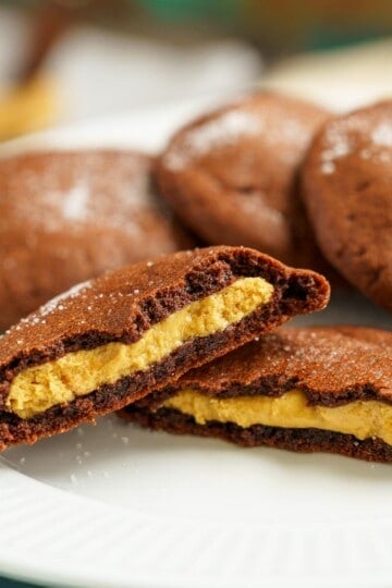 Peanut butter stuffed chocolate cookies split in half to show the peanut butter inside.
